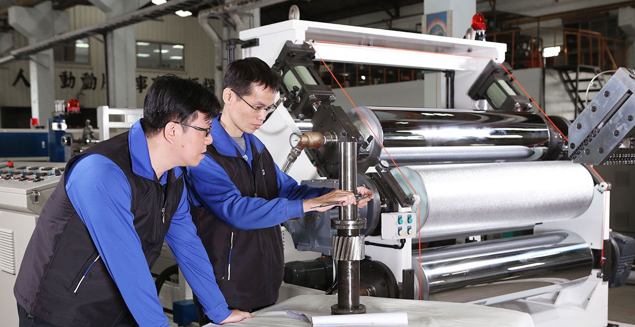 Two technicians inspecting a mechanical shaft.