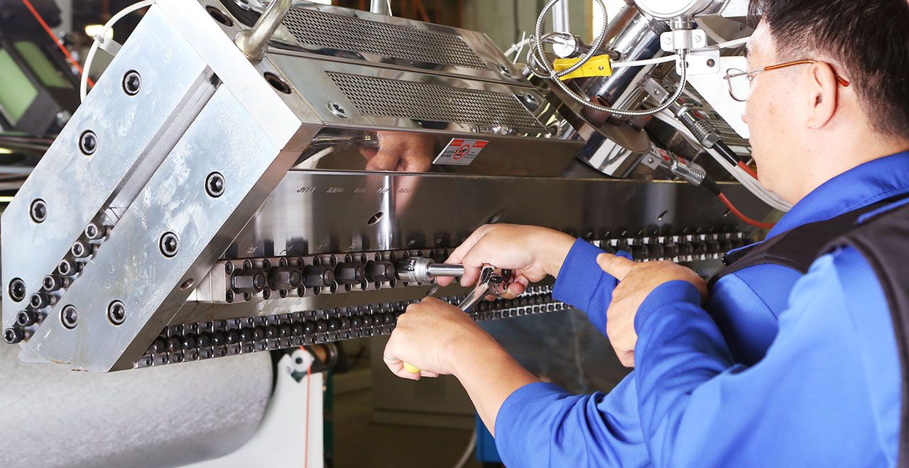 Technician adjusting extrusion machine